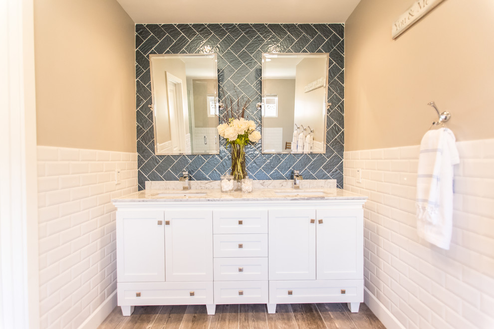 Photo of a large contemporary ensuite bathroom in Phoenix with a submerged sink, shaker cabinets, white cabinets, marble worktops, a freestanding bath, a walk-in shower, a one-piece toilet, white tiles, blue tiles, metro tiles, beige walls, ceramic flooring, brown floors and a hinged door.