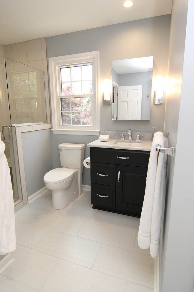Mid-sized minimalist master gray tile and porcelain tile porcelain tile alcove shower photo in Other with an undermount sink, raised-panel cabinets, black cabinets, marble countertops, a two-piece toilet and blue walls
