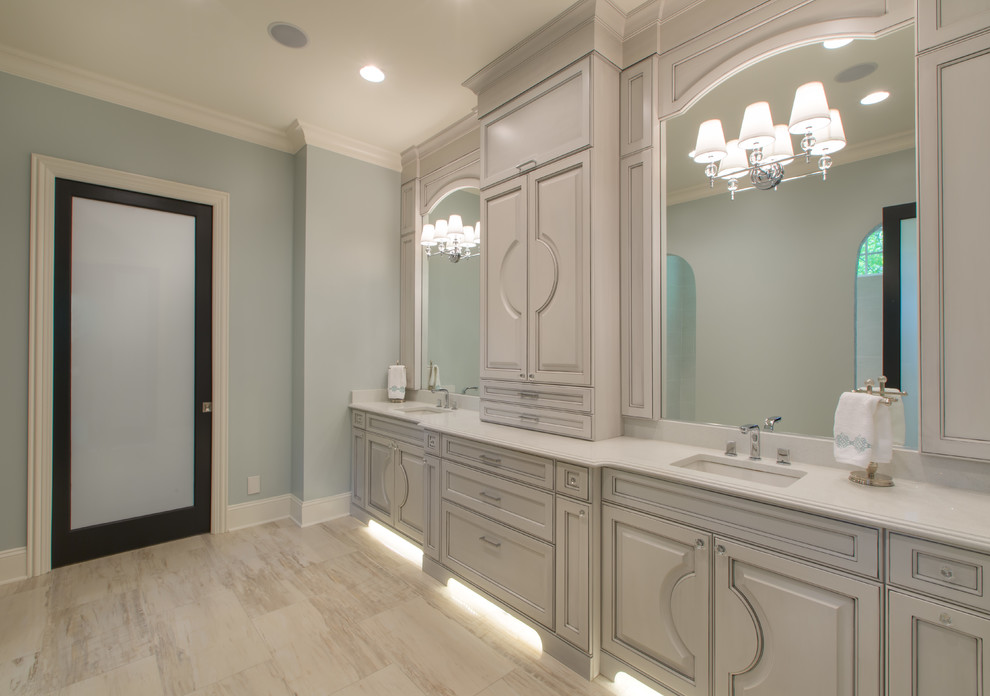 Cette image montre une salle de bain traditionnelle avec un placard en trompe-l'oeil, des portes de placard bleues, une douche ouverte, un carrelage gris, un carrelage de pierre, un mur bleu, un lavabo encastré, un plan de toilette en quartz modifié et un sol en vinyl.