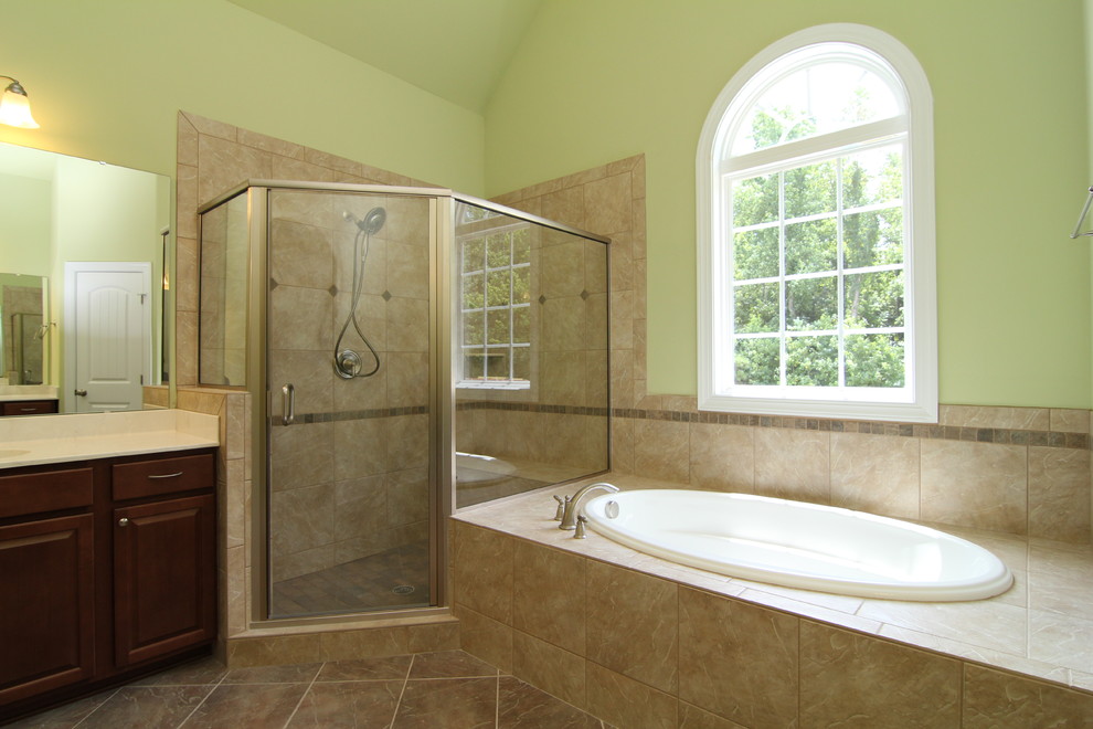 Large elegant master beige tile and ceramic tile ceramic tile bathroom photo in Raleigh with raised-panel cabinets, dark wood cabinets, a one-piece toilet and green walls