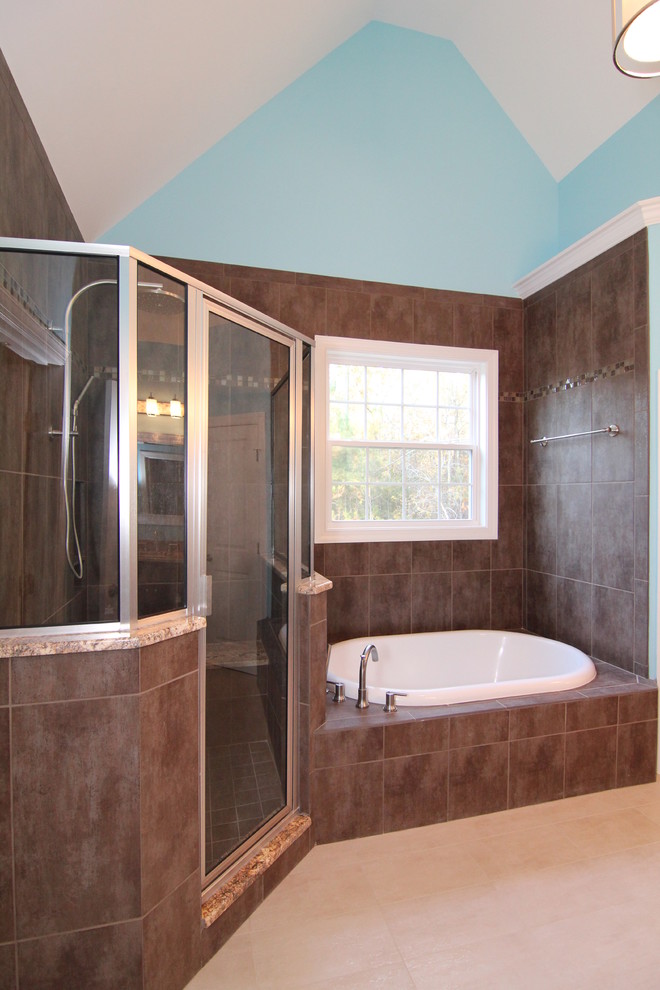 This is an example of a large traditional ensuite bathroom in Raleigh with a submerged sink, recessed-panel cabinets, dark wood cabinets, granite worktops, a built-in bath, a corner shower, a one-piece toilet, brown tiles, ceramic tiles, blue walls and ceramic flooring.