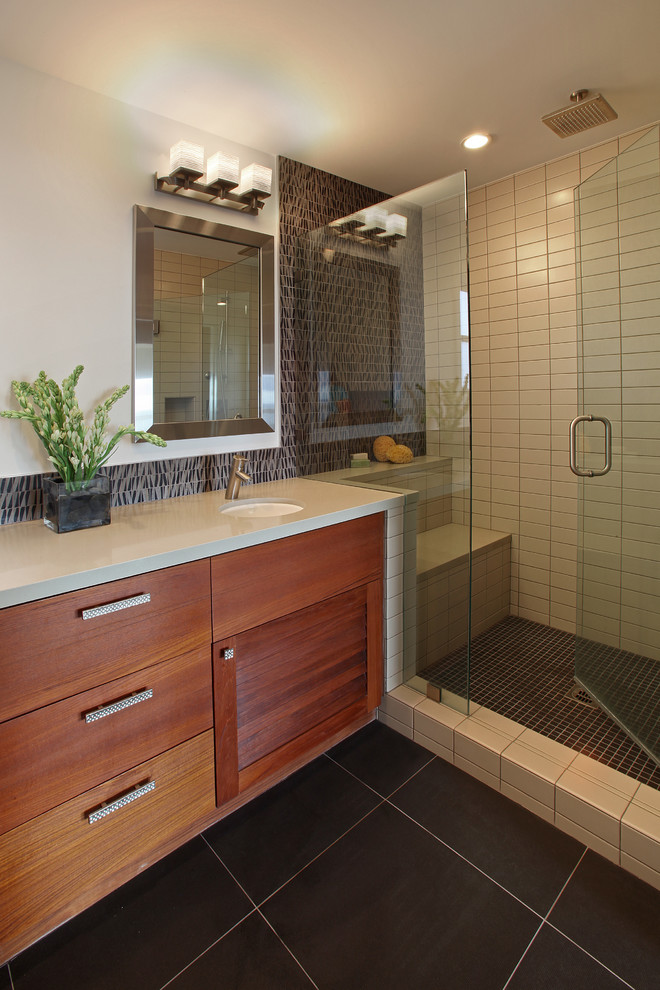 Inspiration for a small modern ensuite bathroom in Orange County with medium wood cabinets, black tiles, stone tiles, white walls, porcelain flooring, a submerged sink, engineered stone worktops, recessed-panel cabinets, an alcove shower, black floors and a hinged door.