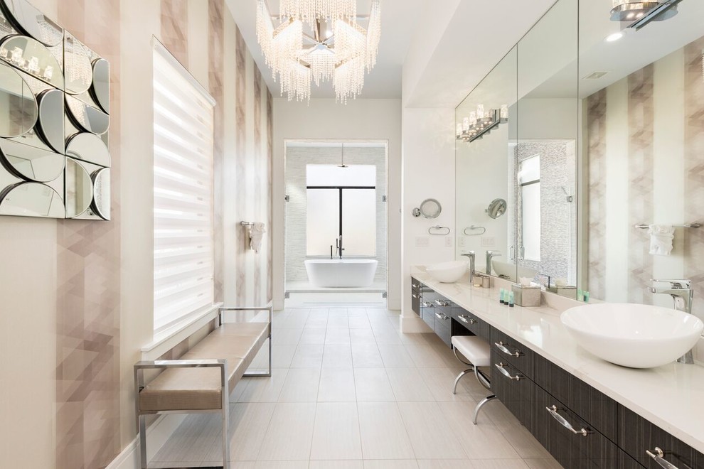 Foto på ett funkis badrum, med släta luckor, grå skåp, ett fristående badkar, vita väggar, ett fristående handfat och grått golv