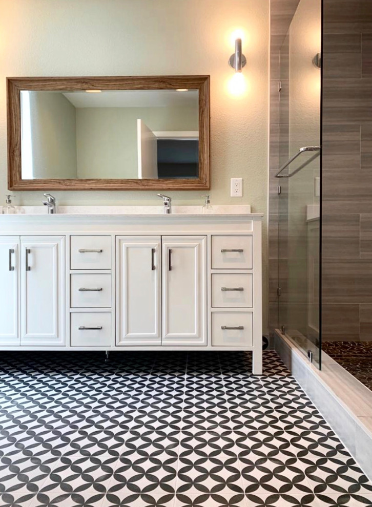 Réalisation d'une salle de bain design avec des portes de placard beiges, un bain bouillonnant, un carrelage gris, des carreaux de porcelaine, un plan de toilette en quartz et un plan de toilette blanc.