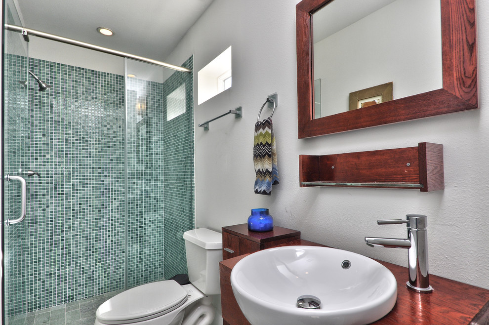 This is an example of a large contemporary shower room bathroom in Tampa with flat-panel cabinets, medium wood cabinets, an alcove shower, a two-piece toilet, blue tiles, mosaic tiles, white walls, ceramic flooring, a vessel sink, wooden worktops and a built-in bath.