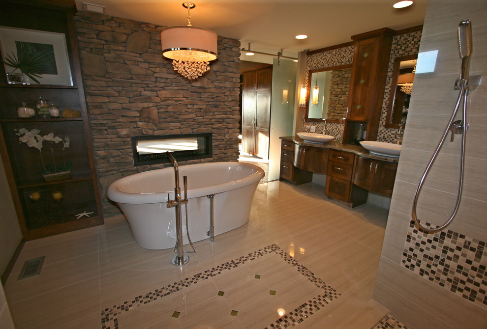 Aménagement d'une salle de bain principale contemporaine en bois brun de taille moyenne avec une vasque, un placard à porte shaker, un plan de toilette en granite, une baignoire indépendante, un carrelage beige et un sol en carrelage de porcelaine.