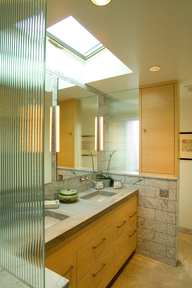 На фото: ванная комната среднего размера в современном стиле с плоскими фасадами, светлыми деревянными фасадами, столешницей из бетона, серой плиткой и белыми стенами