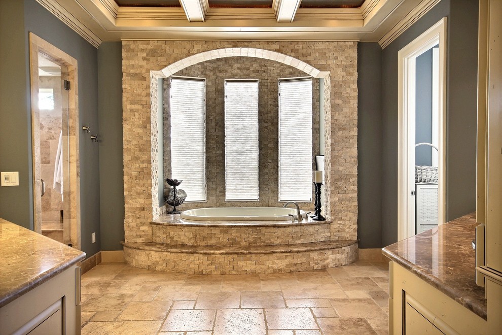 Idéer för att renovera ett mycket stort vintage en-suite badrum, med luckor med upphöjd panel, beige skåp, ett badkar i en alkov, en dubbeldusch, beige kakel, stenhäll, blå väggar, travertin golv, ett undermonterad handfat och marmorbänkskiva