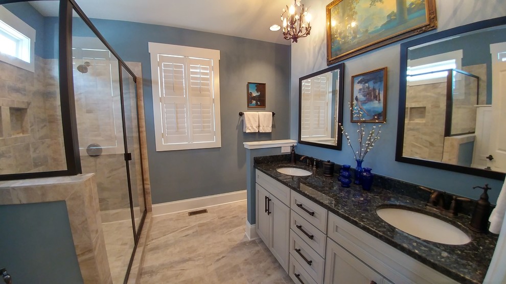 Bild på ett mellanstort amerikanskt en-suite badrum, med luckor med infälld panel, vita skåp, vit kakel, blå väggar, ett undermonterad handfat, granitbänkskiva och dusch med gångjärnsdörr