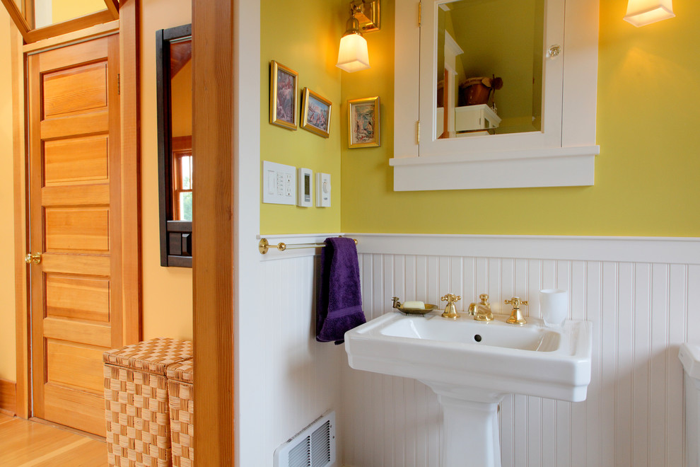 Imagen de cuarto de baño principal de estilo americano pequeño con lavabo con pedestal, combinación de ducha y bañera, sanitario de dos piezas, baldosas y/o azulejos blancos y paredes amarillas