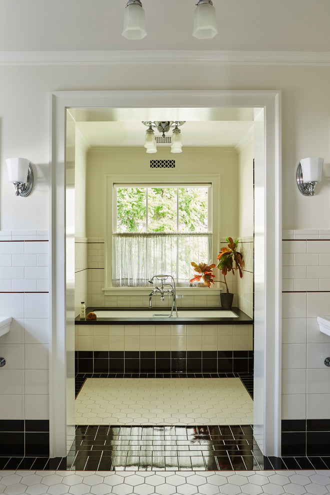 Esempio di una stanza da bagno padronale tradizionale con pistrelle in bianco e nero, pareti bianche, vasca sottopiano e pavimento multicolore