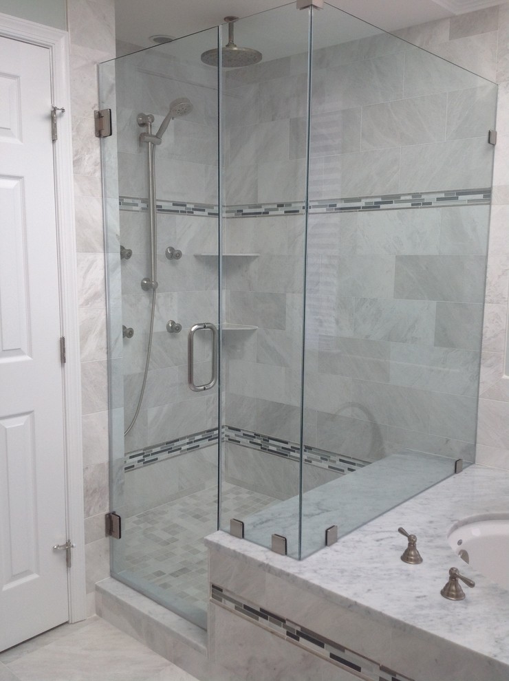 Modern inredning av ett mellanstort en-suite badrum, med luckor med profilerade fronter, grå skåp, ett undermonterat badkar, en dusch i en alkov, en toalettstol med hel cisternkåpa, stenkakel, blå väggar, marmorgolv, ett undermonterad handfat och marmorbänkskiva
