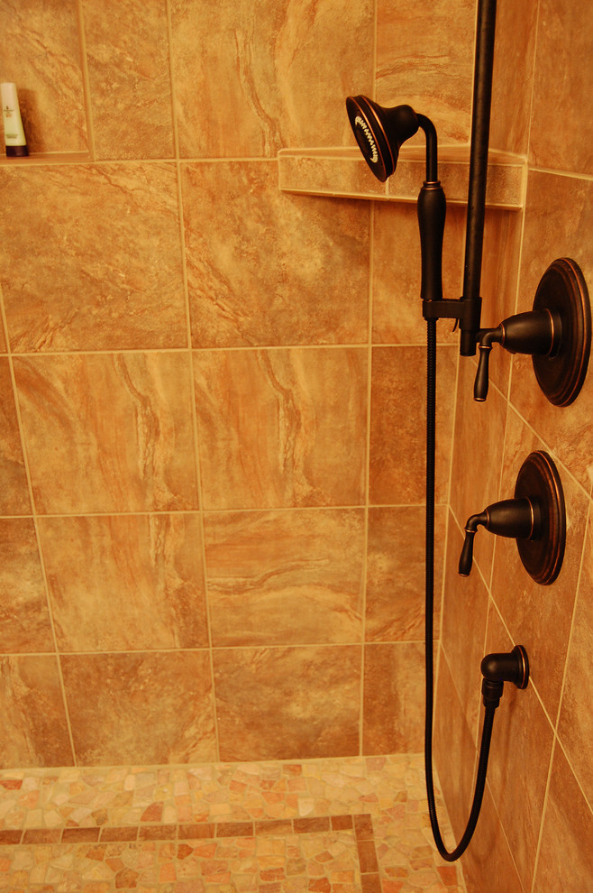 Classic ensuite bathroom in Other with beige tiles, porcelain tiles and pebble tile flooring.