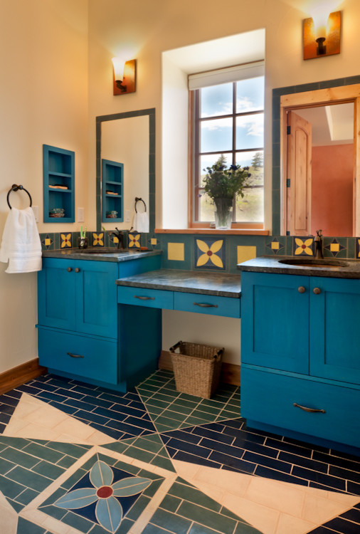 Cette photo montre une salle de bain principale sud-ouest américain de taille moyenne avec un placard à porte shaker, des portes de placard bleues, une baignoire en alcôve, WC séparés, un carrelage multicolore, des carreaux en terre cuite, un sol en carrelage de terre cuite, un lavabo encastré, un plan de toilette en stéatite et un sol multicolore.
