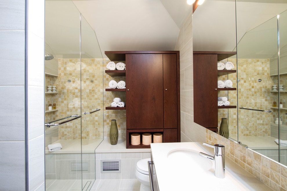This is an example of a medium sized contemporary ensuite bathroom in Philadelphia with flat-panel cabinets, dark wood cabinets, a built-in shower, a one-piece toilet, beige tiles, porcelain tiles, white walls, an integrated sink, quartz worktops, a built-in bath, porcelain flooring, beige floors and a hinged door.