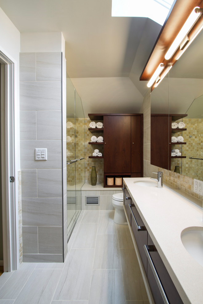 Medium sized modern ensuite bathroom in New York with flat-panel cabinets, dark wood cabinets, a built-in shower, a one-piece toilet, beige tiles, porcelain tiles, quartz worktops, a submerged sink, a corner bath, beige walls, porcelain flooring, beige floors and a hinged door.