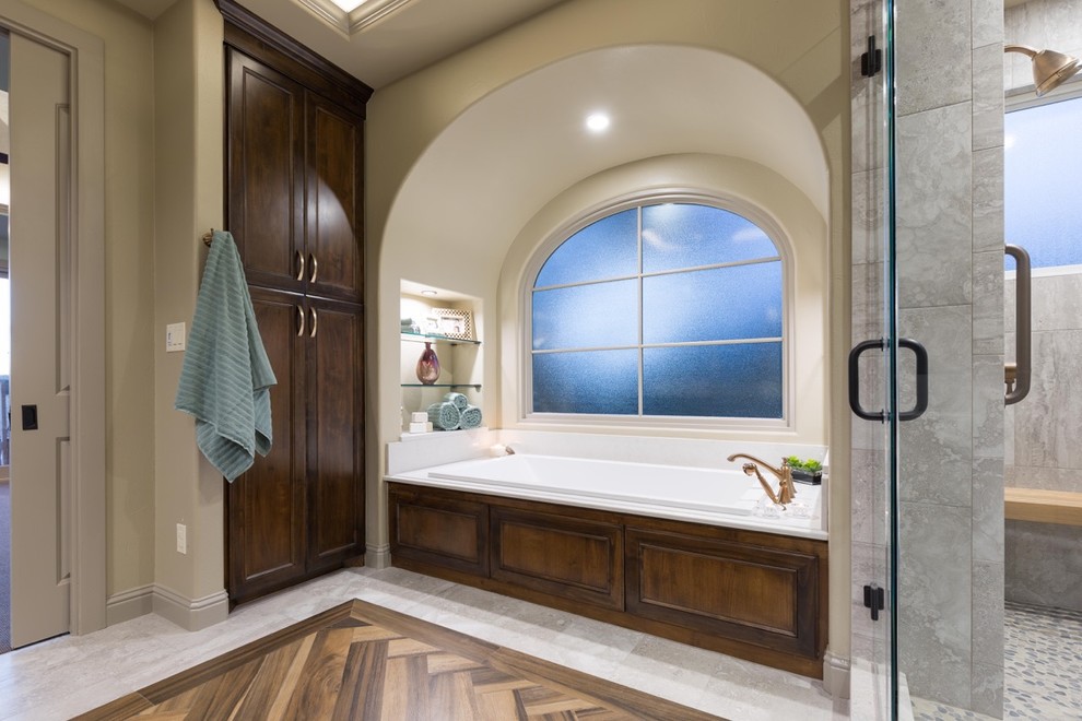 Photo of a medium sized traditional ensuite bathroom in Austin with flat-panel cabinets, dark wood cabinets, a built-in bath, an alcove shower, a two-piece toilet, grey tiles, porcelain tiles, beige walls, porcelain flooring, engineered stone worktops and a submerged sink.
