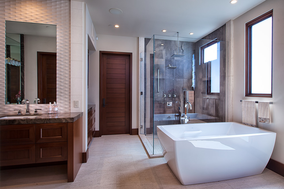 Cette image montre une grande salle de bain principale design en bois brun avec un lavabo encastré, un placard à porte shaker, une baignoire indépendante, une douche d'angle, un carrelage marron, un carrelage de pierre, un mur beige, un sol en calcaire et un plan de toilette en marbre.