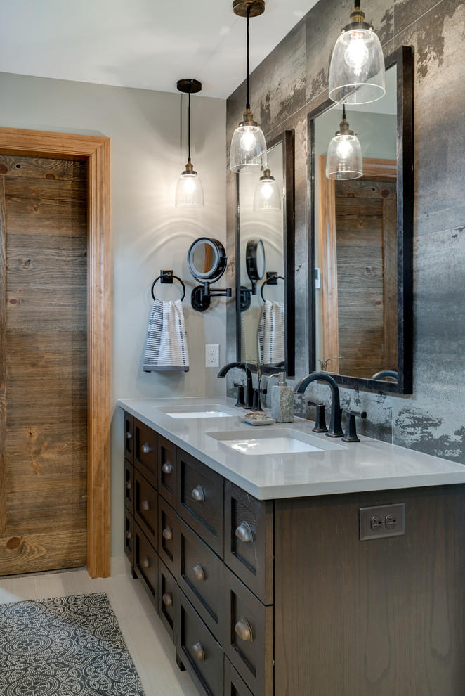Modelo de cuarto de baño de estilo de casa de campo con armarios estilo shaker, puertas de armario de madera en tonos medios, paredes grises, lavabo bajoencimera, suelo blanco y encimeras grises