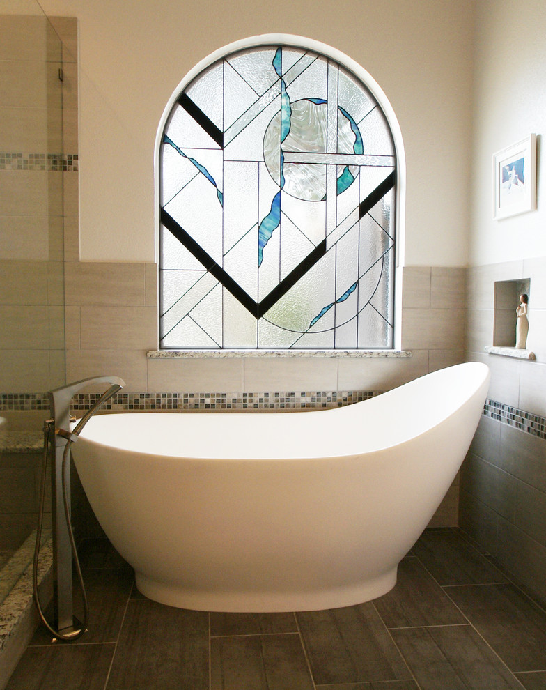Cette photo montre une salle de bain principale chic de taille moyenne avec une baignoire indépendante, des carreaux de porcelaine et un sol en carrelage de porcelaine.
