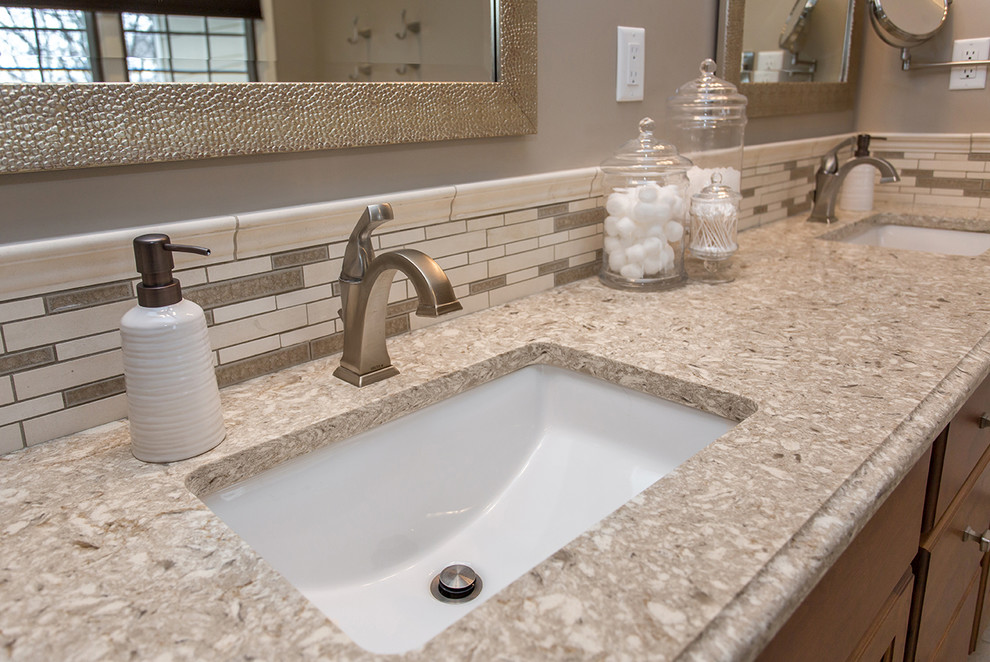 Bathroom - mid-sized traditional master beige tile and ceramic tile ceramic tile and beige floor bathroom idea in Other with raised-panel cabinets, medium tone wood cabinets, a two-piece toilet, beige walls, an undermount sink, quartz countertops, a hinged shower door and beige countertops