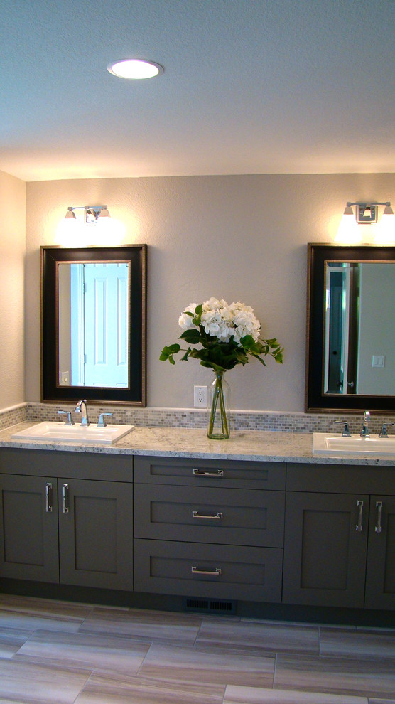 Cette image montre une grande salle de bain principale traditionnelle avec un lavabo posé, un placard à porte shaker, des portes de placard grises, un plan de toilette en granite, une baignoire posée, un carrelage gris, mosaïque, un mur gris et un sol en carrelage de porcelaine.