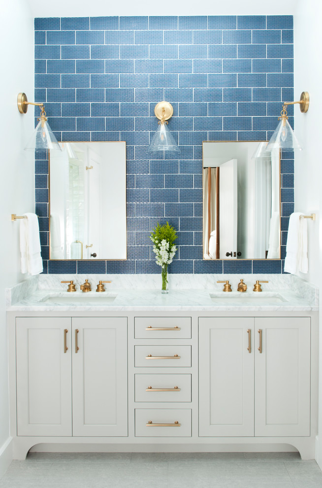 Klassisk inredning av ett vit vitt badrum, med skåp i shakerstil, vita skåp, blå kakel, tunnelbanekakel, vita väggar, ett undermonterad handfat och vitt golv