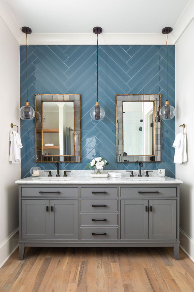 Пример оригинального дизайна: большая главная ванная комната в стиле неоклассика (современная классика) с серыми фасадами, синей плиткой, мраморной столешницей, белыми стенами, светлым паркетным полом, врезной раковиной, белой столешницей, зеркалом с подсветкой и фасадами с декоративным кантом