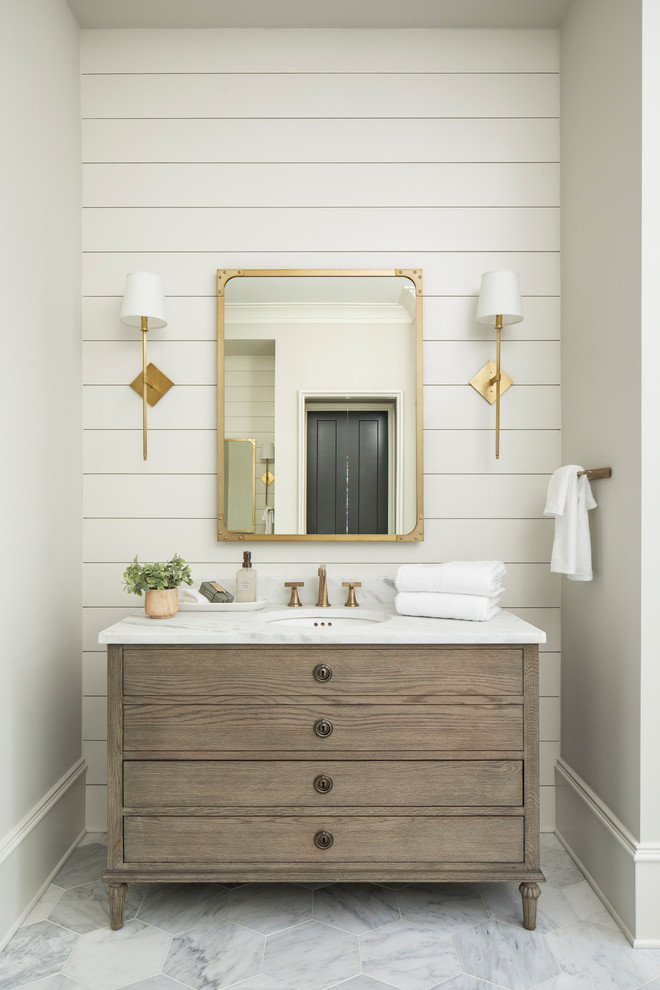Aménagement d'une grande salle de bain principale classique en bois brun avec un placard en trompe-l'oeil, un mur beige, un sol en marbre, un lavabo encastré, un plan de toilette en marbre et un plan de toilette blanc.