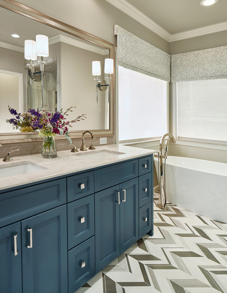 Example of a mid-sized transitional master multicolored tile and stone tile mosaic tile floor bathroom design in Dallas with shaker cabinets, blue cabinets, a two-piece toilet, beige walls, an undermount sink and limestone countertops