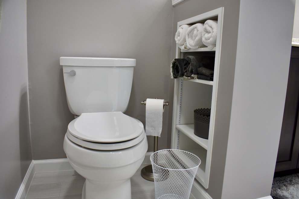 Exemple d'une grande salle de bain principale chic en bois foncé avec un placard avec porte à panneau encastré, une douche d'angle, WC à poser, un mur gris, un lavabo encastré, un plan de toilette en quartz modifié et une cabine de douche à porte battante.