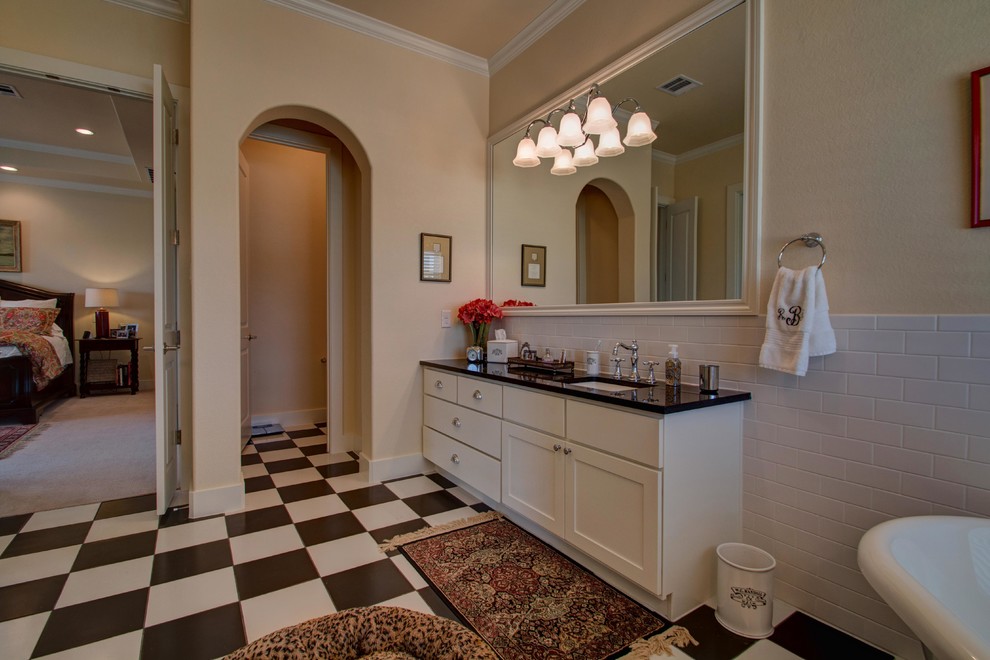 Foto på ett lantligt svart en-suite badrum, med skåp i shakerstil, vita skåp, ett fristående badkar, vit kakel, tunnelbanekakel, beige väggar, klinkergolv i porslin, ett undermonterad handfat, granitbänkskiva och flerfärgat golv