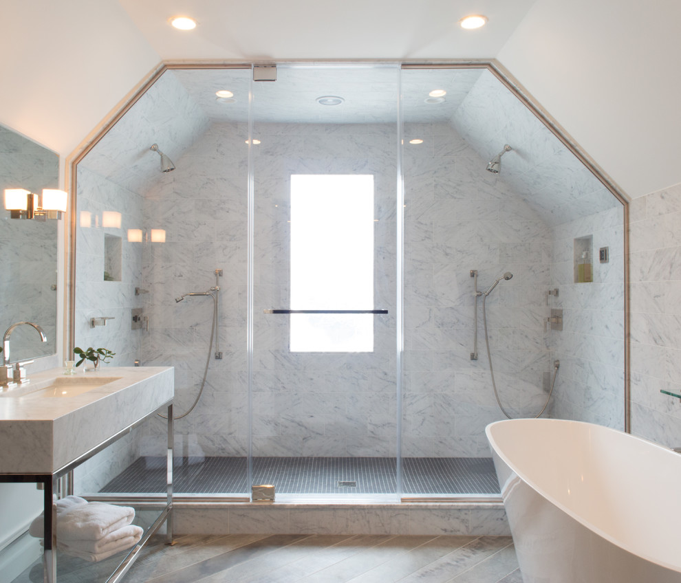 Idéer för ett stort klassiskt en-suite badrum, med öppna hyllor, vita skåp, ett fristående badkar, en dubbeldusch, grå kakel, marmorkakel, vita väggar, mellanmörkt trägolv, ett konsol handfat, marmorbänkskiva, brunt golv och dusch med gångjärnsdörr