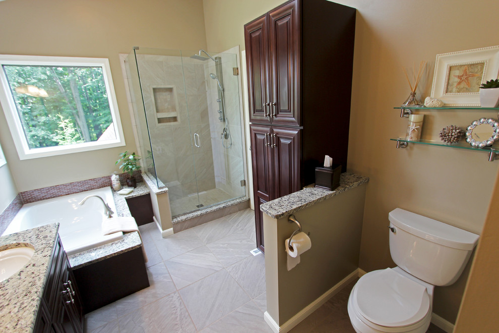 Bild på ett mellanstort vintage en-suite badrum, med ett undermonterad handfat, luckor med upphöjd panel, skåp i mörkt trä, granitbänkskiva, ett hörnbadkar, en hörndusch, grå kakel, porslinskakel, beige väggar och klinkergolv i porslin