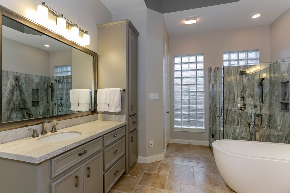 Modelo de cuarto de baño principal moderno grande con armarios estilo shaker, puertas de armario grises, bañera exenta, ducha esquinera, baldosas y/o azulejos multicolor, losas de piedra y paredes grises