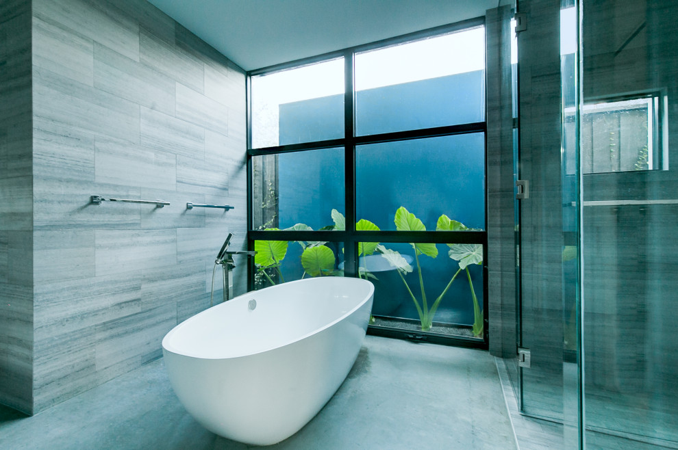 Diseño de cuarto de baño principal moderno con bañera exenta, ducha abierta, paredes grises, suelo de cemento, suelo gris y ducha con puerta con bisagras