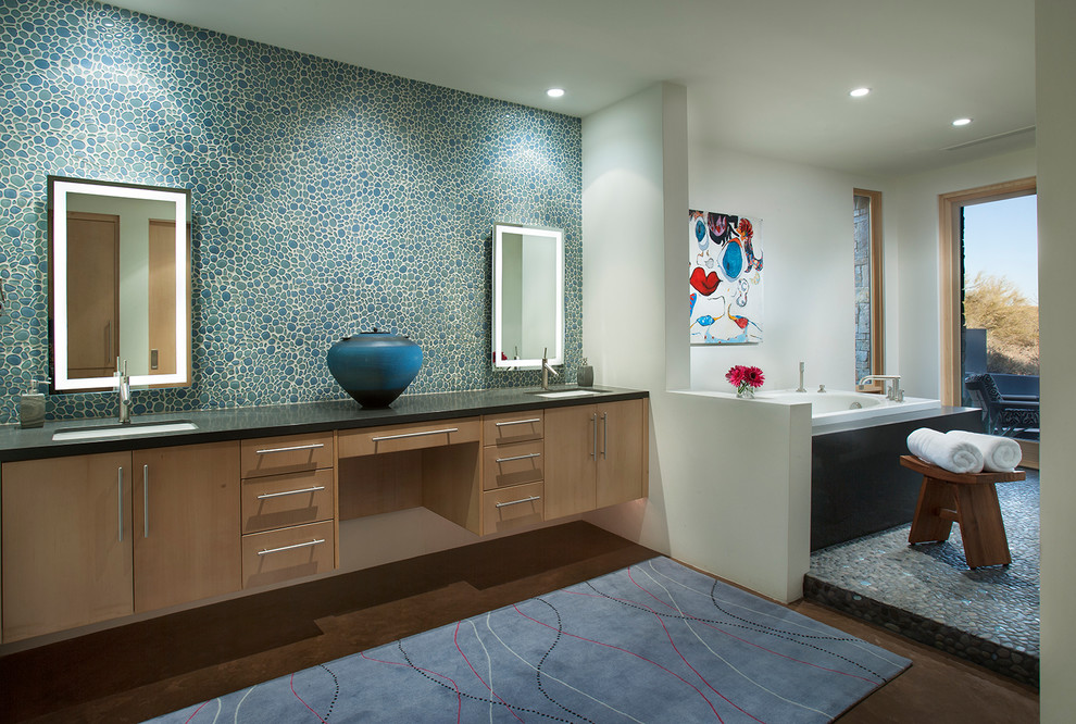 Идея дизайна: главная ванная комната среднего размера в современном стиле с врезной раковиной, плоскими фасадами, светлыми деревянными фасадами, столешницей из искусственного кварца, накладной ванной, синей плиткой, галечной плиткой, белыми стенами, полом из галечной плитки, душем без бортиков, инсталляцией, серым полом и душем с распашными дверями