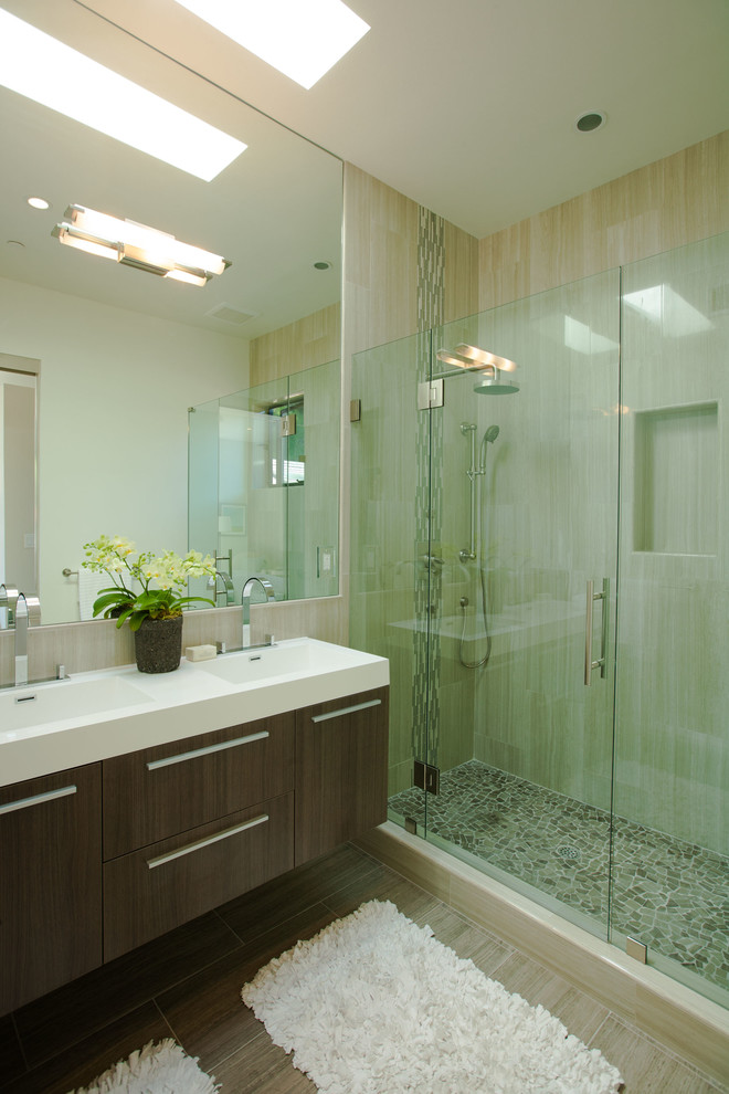 Kleines Modernes Duschbad mit integriertem Waschbecken, flächenbündigen Schrankfronten, dunklen Holzschränken, Mineralwerkstoff-Waschtisch, Eckdusche, beigen Fliesen, Porzellanfliesen, beiger Wandfarbe und Porzellan-Bodenfliesen in San Francisco