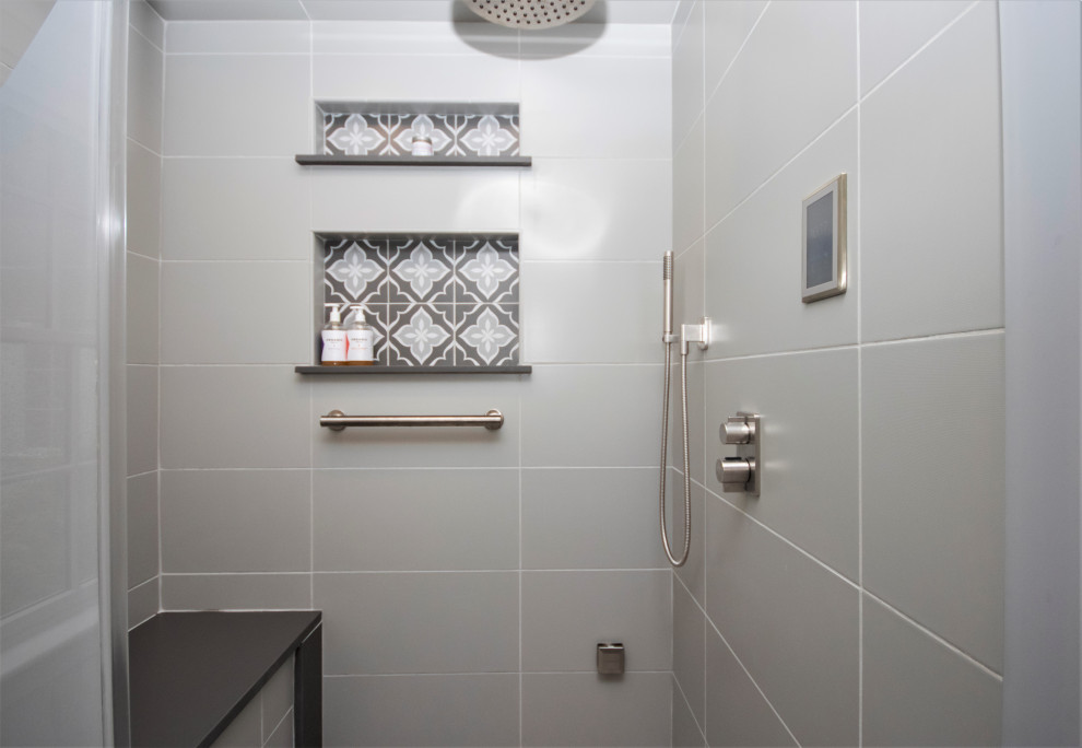 Photo of a large classic ensuite bathroom in Boston with recessed-panel cabinets, white cabinets, a corner shower, a two-piece toilet, grey tiles, ceramic tiles, white walls, ceramic flooring, a submerged sink, engineered stone worktops, grey floors, a hinged door, grey worktops, a shower bench, a single sink and a built in vanity unit.