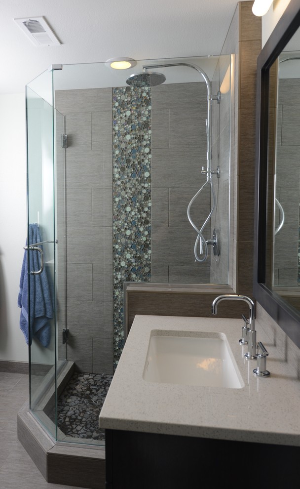 Cette photo montre une salle de bain principale tendance en bois foncé de taille moyenne avec un lavabo encastré, un placard avec porte à panneau encastré, un plan de toilette en quartz modifié, une douche d'angle, un carrelage gris, un carrelage métro, un mur blanc et un sol en carrelage de céramique.
