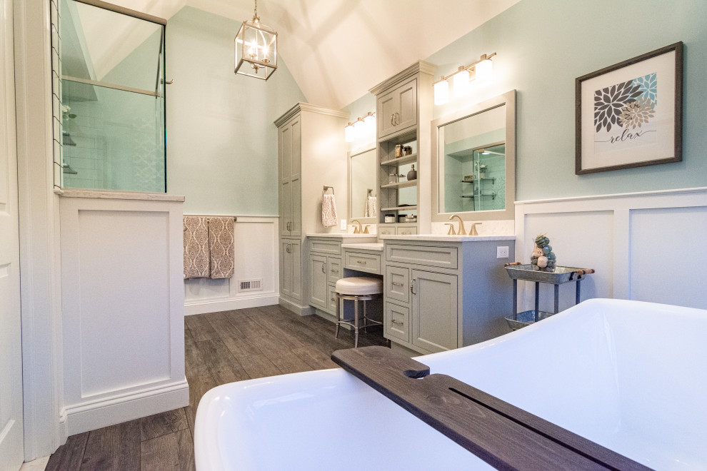 Пример оригинального дизайна: большая главная ванная комната в классическом стиле с плоскими фасадами, серыми фасадами, отдельно стоящей ванной, душем в нише, раздельным унитазом, белой плиткой, керамической плиткой, зелеными стенами, полом из керамогранита, врезной раковиной, столешницей из искусственного кварца, коричневым полом, душем с распашными дверями и белой столешницей