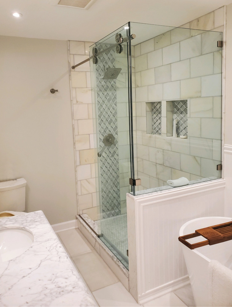 Источник вдохновения для домашнего уюта: главная ванная комната среднего размера в современном стиле с фасадами островного типа, белыми фасадами, отдельно стоящей ванной, угловым душем, унитазом-моноблоком, белой плиткой, мраморной плиткой, белыми стенами, мраморным полом, врезной раковиной, мраморной столешницей, белым полом, душем с раздвижными дверями, белой столешницей, тумбой под две раковины и напольной тумбой