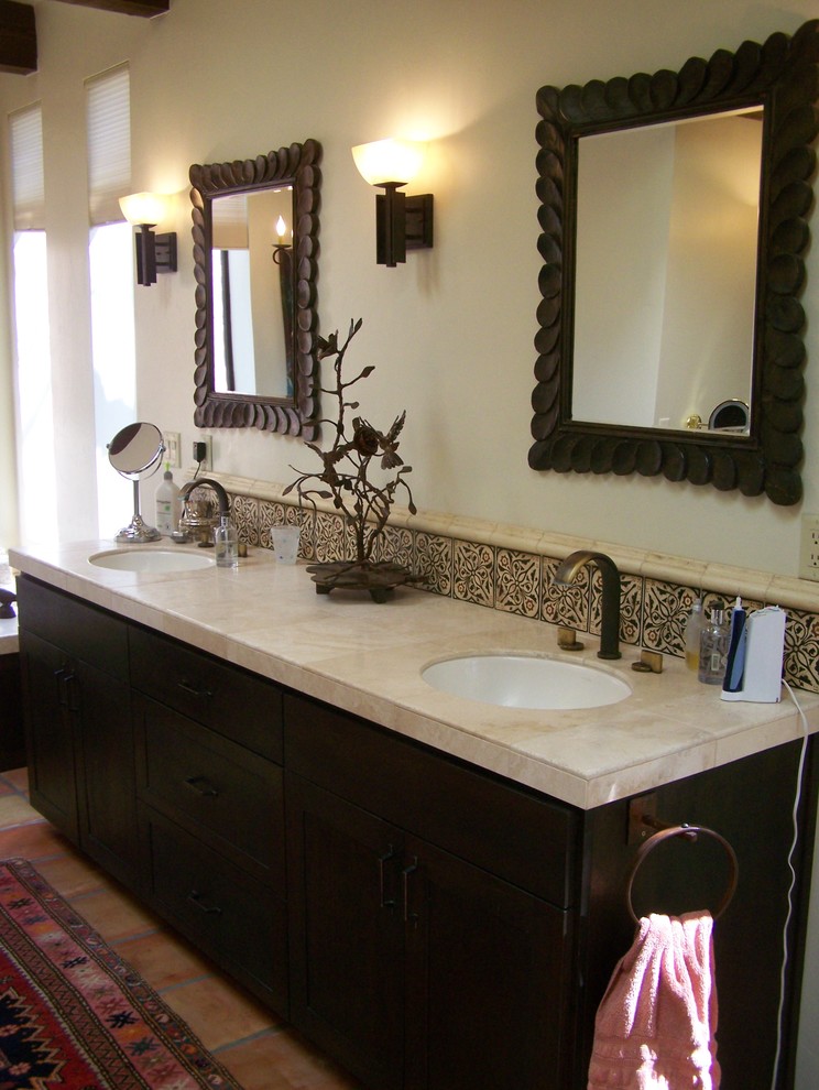 Idée de décoration pour une salle de bain principale sud-ouest américain en bois foncé de taille moyenne avec un placard à porte shaker, une baignoire posée, un mur beige, tomettes au sol, un lavabo encastré et un sol rouge.