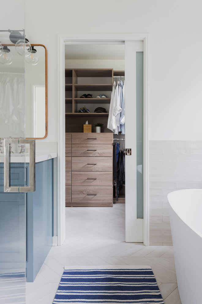 Пример оригинального дизайна: главная ванная комната среднего размера в современном стиле с фасадами в стиле шейкер, синими фасадами, отдельно стоящей ванной, угловым душем, бежевой плиткой, плиткой кабанчик, белыми стенами, полом из керамогранита, врезной раковиной, мраморной столешницей, белым полом и душем с распашными дверями