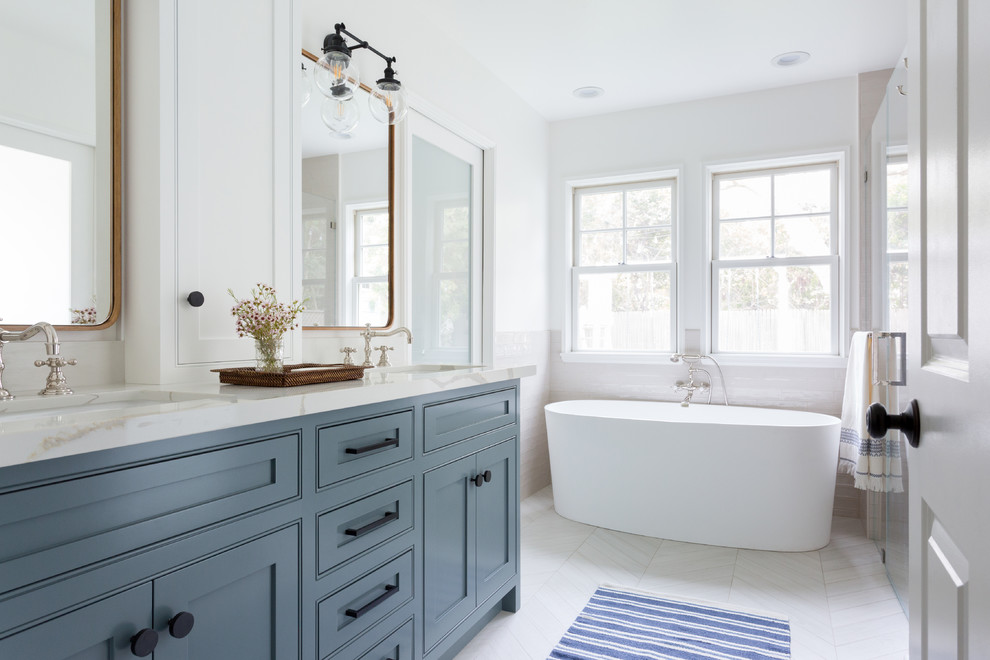 Exempel på ett mellanstort modernt beige beige en-suite badrum, med ett fristående badkar, ett undermonterad handfat, skåp i shakerstil, blå skåp, en hörndusch, beige kakel, vita väggar, dusch med gångjärnsdörr, klinkergolv i porslin, marmorbänkskiva, vitt golv och tunnelbanekakel