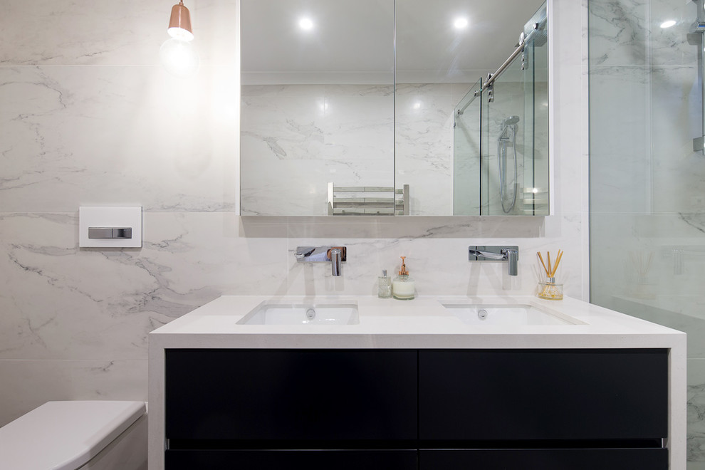 Exempel på ett mellanstort modernt en-suite badrum, med släta luckor, svarta skåp, en vägghängd toalettstol, grå kakel, keramikplattor, flerfärgade väggar, klinkergolv i keramik, ett undermonterad handfat och granitbänkskiva