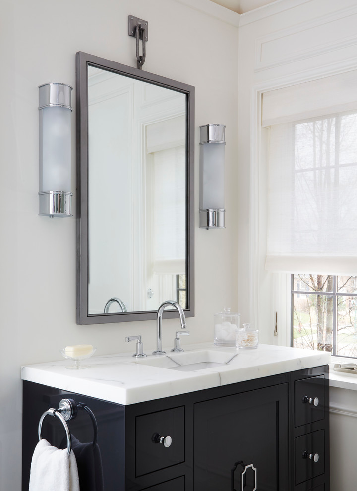 Foto di una stanza da bagno padronale classica di medie dimensioni con consolle stile comò, ante nere, piastrelle bianche, pareti bianche, pavimento in marmo, lavabo integrato e top in marmo