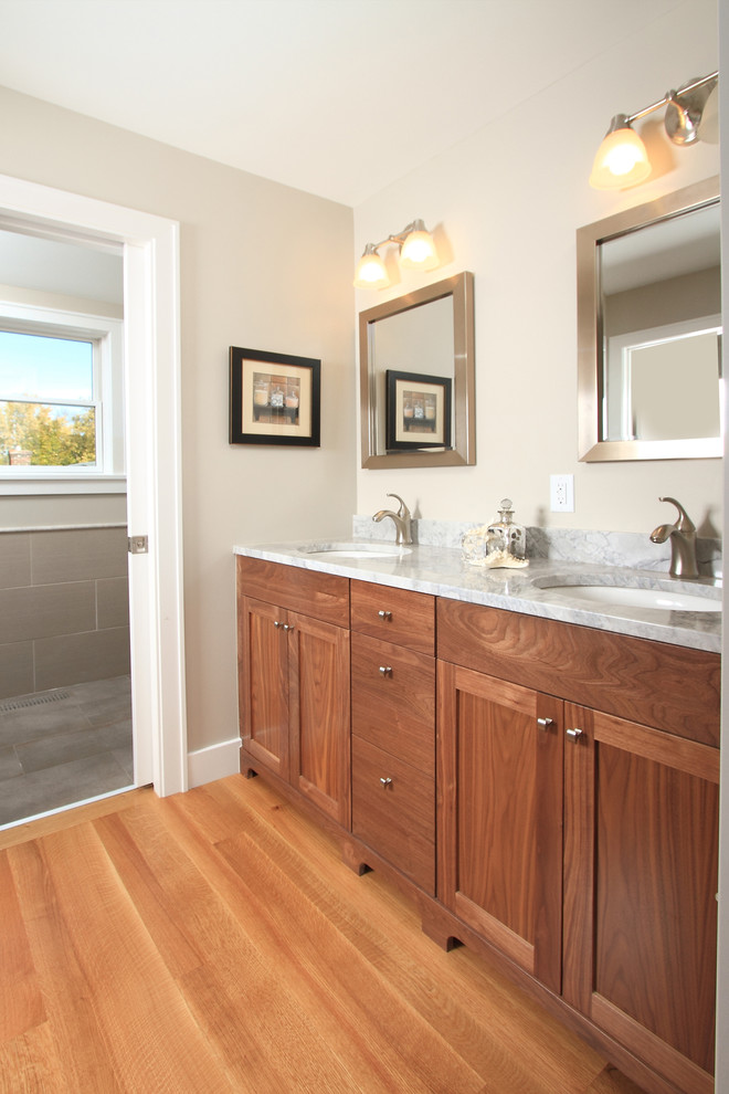 ミネアポリスにあるトラディショナルスタイルのおしゃれな浴室 (アンダーカウンター洗面器、シェーカースタイル扉のキャビネット、中間色木目調キャビネット) の写真