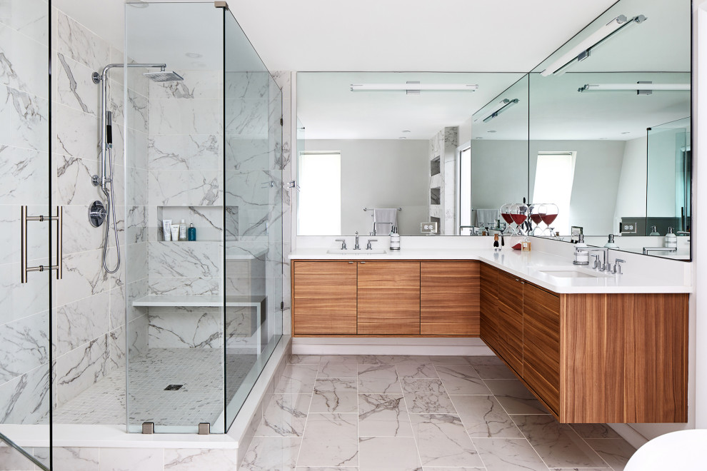 Réalisation d'une grande salle de bain design avec des portes de placard marrons, une douche d'angle, un carrelage gris, une cabine de douche à porte battante et un plan de toilette blanc.