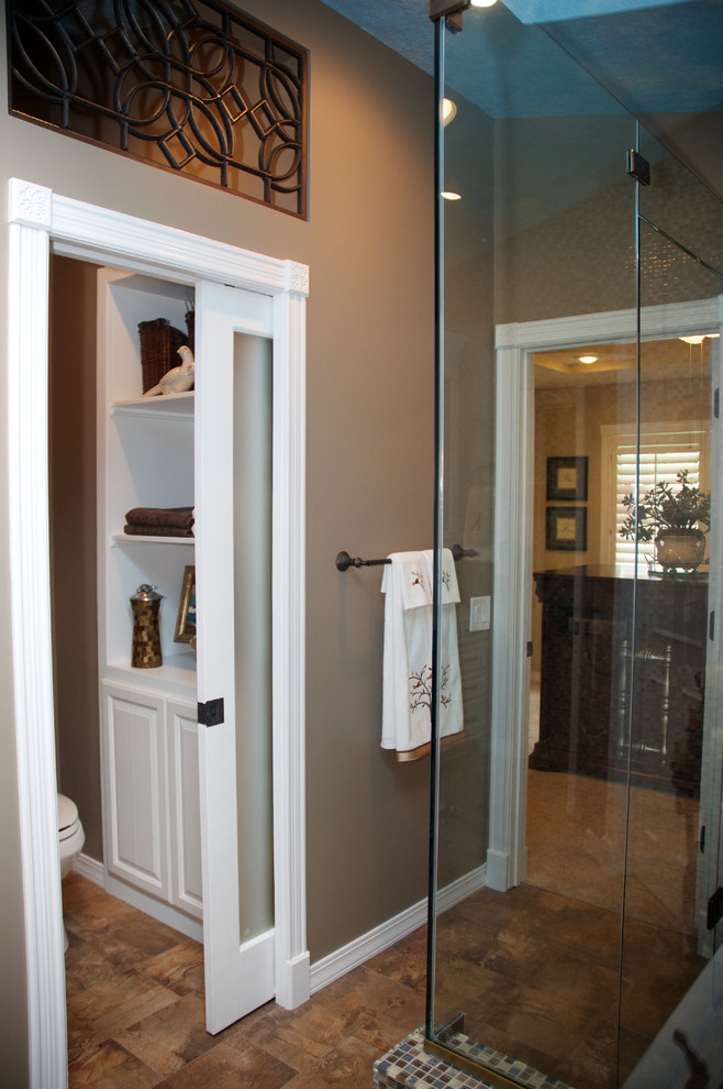Foto på ett mellanstort vintage en-suite badrum, med ett undermonterad handfat, vita skåp, bänkskiva i kvarts, en kantlös dusch, mosaik, beige väggar, klinkergolv i porslin, en toalettstol med separat cisternkåpa och brun kakel